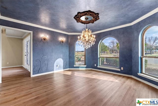 interior space with wood-type flooring, crown molding, and a notable chandelier