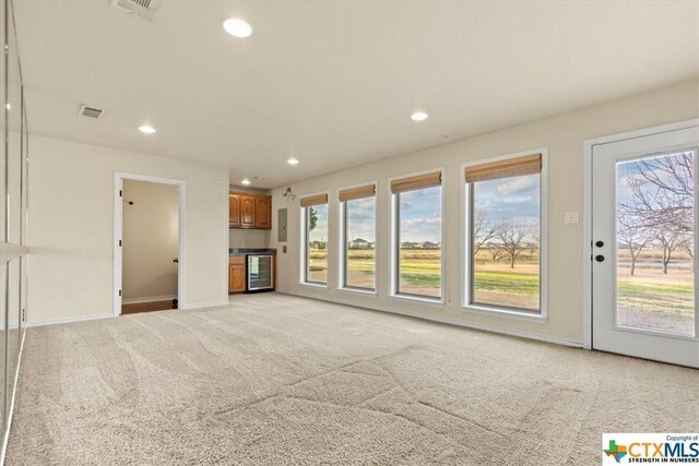 6503 Wells Fargo Rd, Killeen, TX 76542 - unfurnished living room featuring light colored carpet, beverage cooler, recessed lighting, and baseboards