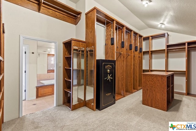 walk in closet featuring light colored carpet and lofted ceiling