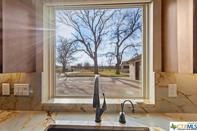 6503 Wells Fargo Rd, Killeen, TX 76542 - kitchen view of a sink, decorative backsplash, and stone countertops