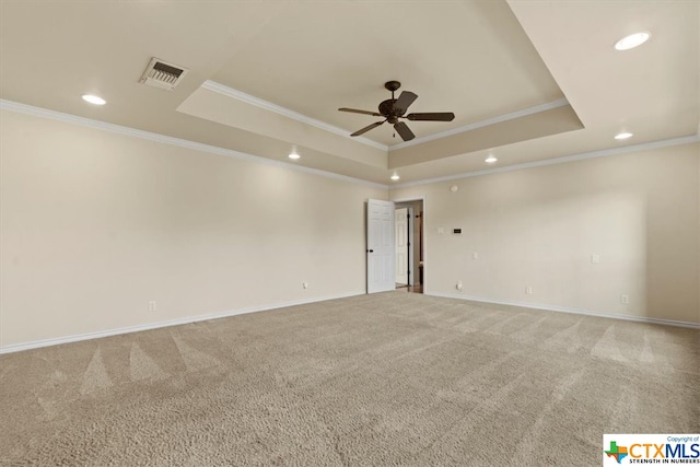 carpeted empty room with ornamental molding, ceiling fan, and a tray ceiling