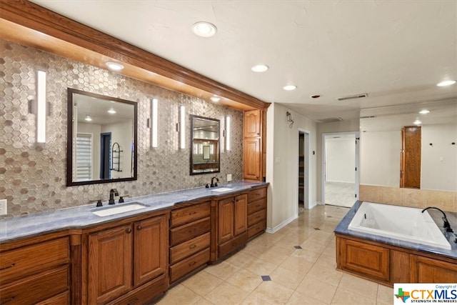 bathroom featuring a bathtub, vanity, and tile patterned floors