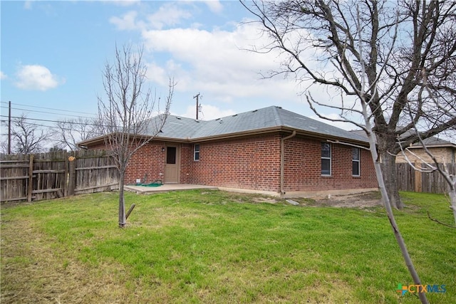 rear view of house with a patio area and a lawn