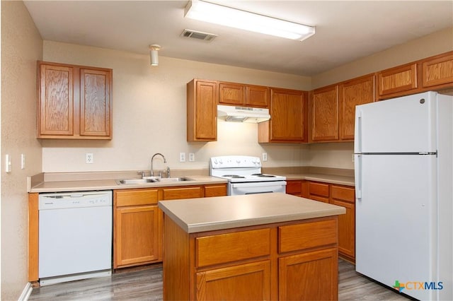 kitchen with a center island, sink, dark wood-type flooring, and white appliances