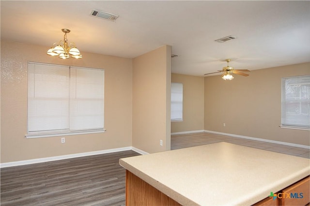 kitchen featuring hanging light fixtures, hardwood / wood-style flooring, and ceiling fan with notable chandelier