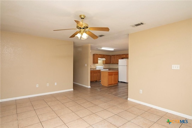 unfurnished living room featuring ceiling fan and light tile patterned floors