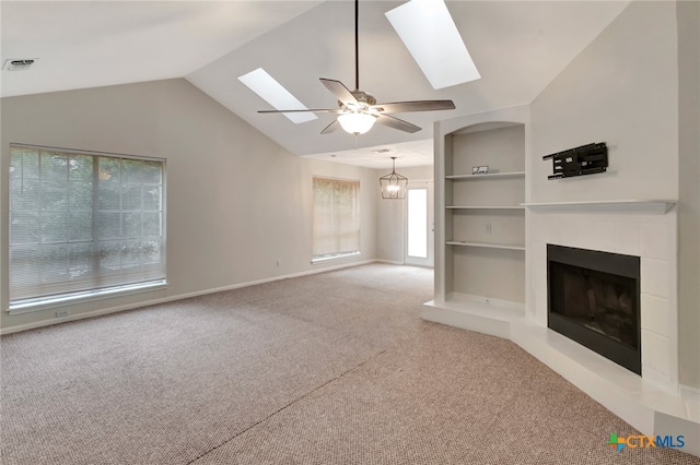 unfurnished living room with vaulted ceiling, built in shelves, carpet, and ceiling fan with notable chandelier