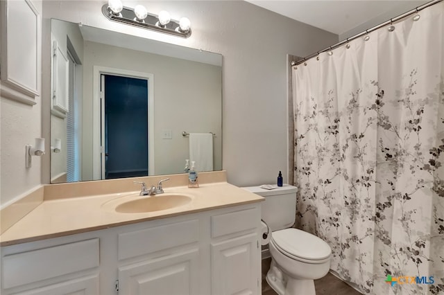 bathroom featuring a shower with curtain, vanity, and toilet