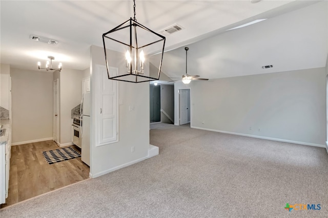 kitchen featuring pendant lighting, ceiling fan with notable chandelier, light colored carpet, and white cabinetry