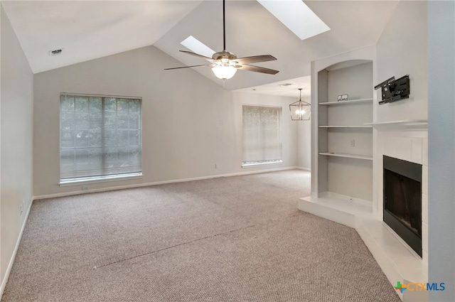 unfurnished living room featuring built in shelves, light carpet, ceiling fan with notable chandelier, and vaulted ceiling