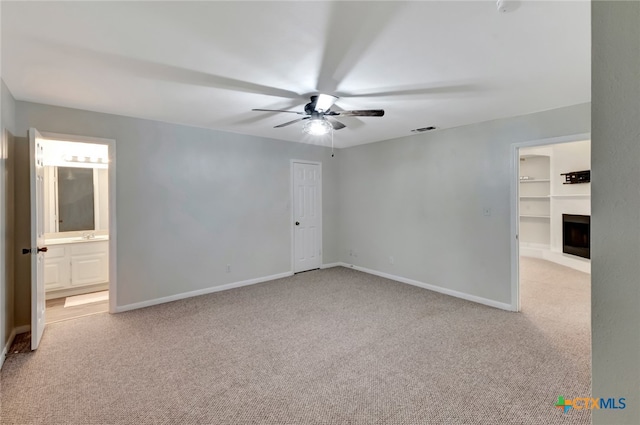 carpeted spare room featuring ceiling fan