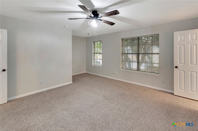 carpeted empty room featuring ceiling fan