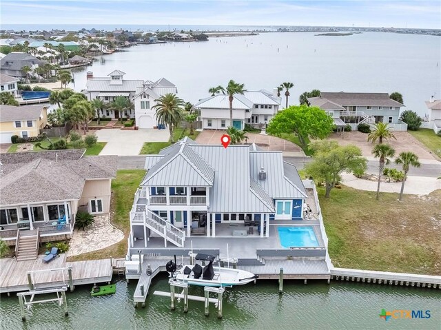 37 Flamingo Rd, Rockport, TX 78382 - rear view of house featuring a water view, metal roof, a residential view, and stairs