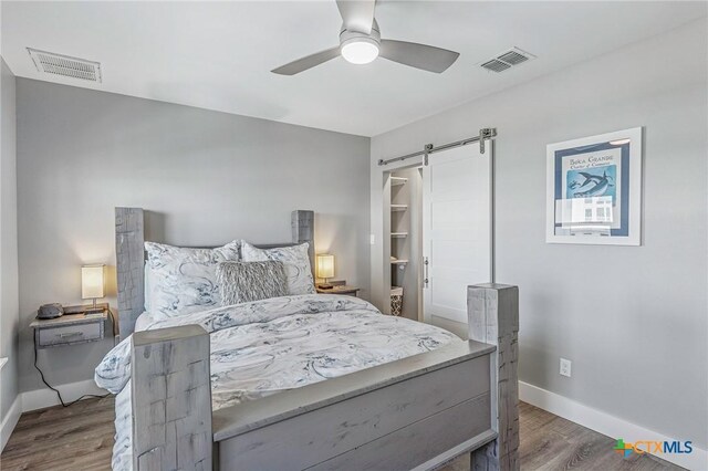 37 Flamingo Rd, Rockport, TX 78382 - bedroom with wood finished floors, baseboards, a barn door, and a ceiling fan