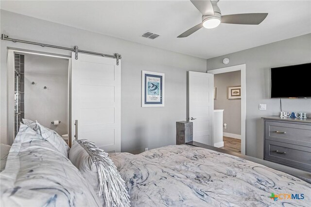 37 Flamingo Rd, Rockport, TX 78382 - bedroom with a barn door, wood finished floors, ceiling fan, and baseboards