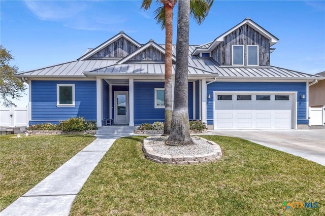 37 Flamingo Rd, Rockport, TX 78382 - view of front of property featuring a standing seam roof, covered porch, an attached garage, concrete driveway, and a front yard
