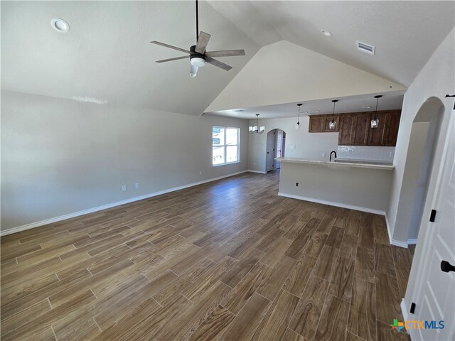 unfurnished living room with dark wood-type flooring, ceiling fan, sink, and high vaulted ceiling