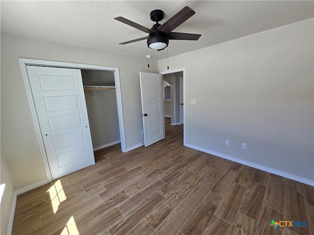 unfurnished bedroom with hardwood / wood-style floors, ceiling fan, a textured ceiling, and a closet