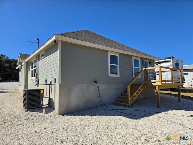 back of house with a wooden deck and cooling unit