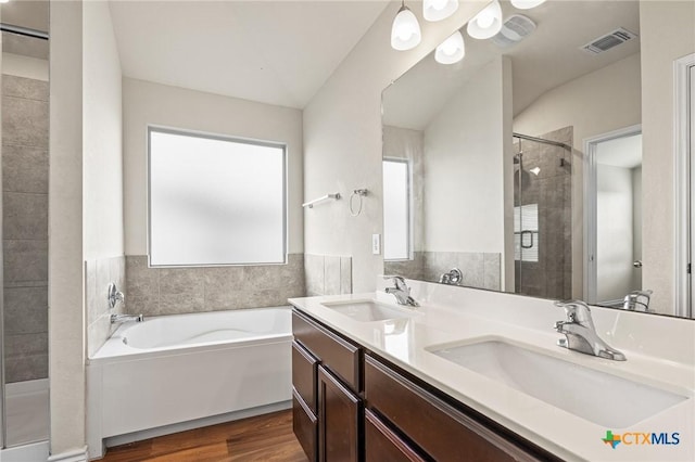 5101 Hacienda Dr, Killeen, TX 76549 - full bathroom with wood finished floors, a bath, a stall shower, and double vanity