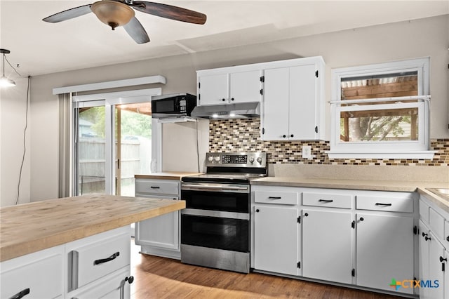 2004 Veterans Ave, Copperas Cove, TX 76522 - kitchen featuring range with two ovens, black microwave, under cabinet range hood, backsplash, and white cabinetry