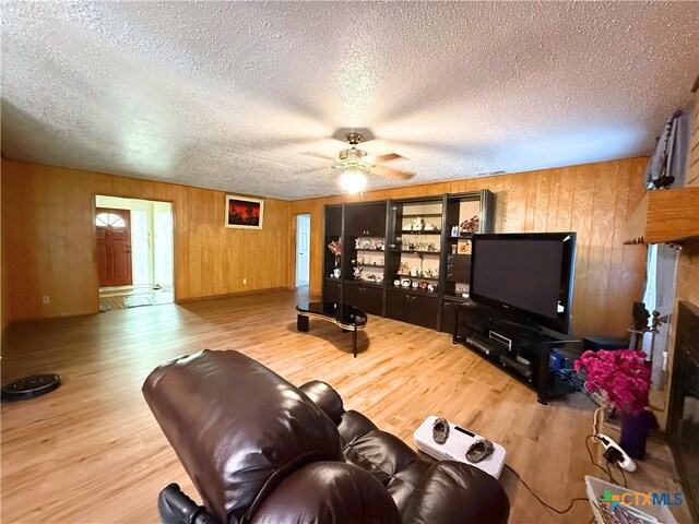 1901 Muir Dr, Killeen, TX 76543 - living area with wood finished floors, ceiling fan, wooden walls, and a textured ceiling