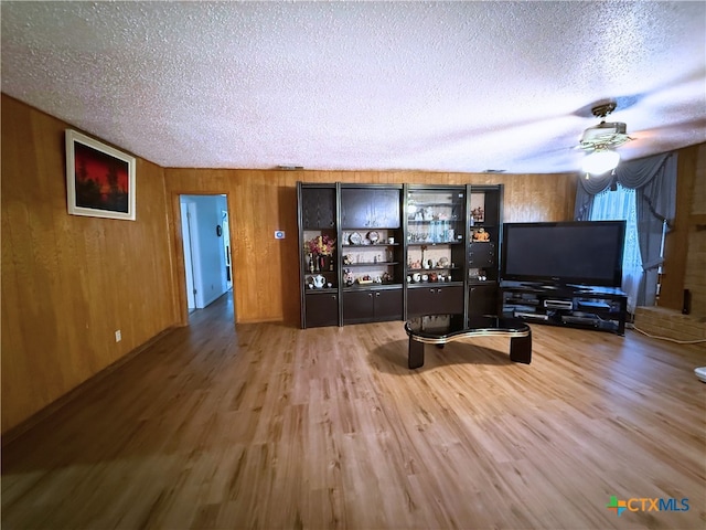 1901 Muir Dr, Killeen, TX 76543 - living area featuring a textured ceiling, wood finished floors, ceiling fan, and wood walls