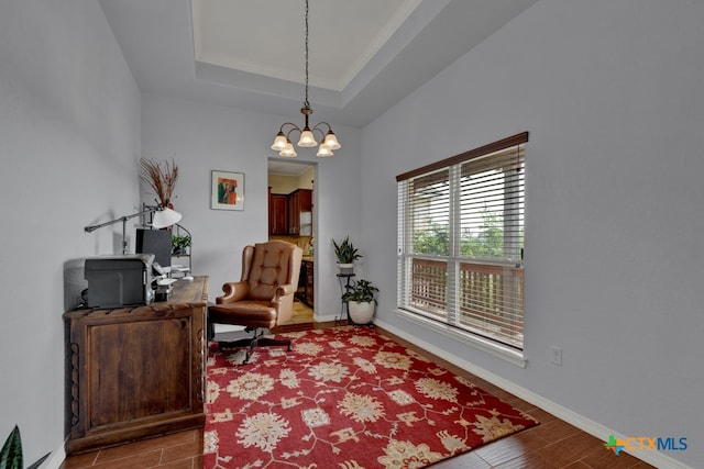 living area with hardwood / wood-style floors, a notable chandelier, and a tray ceiling