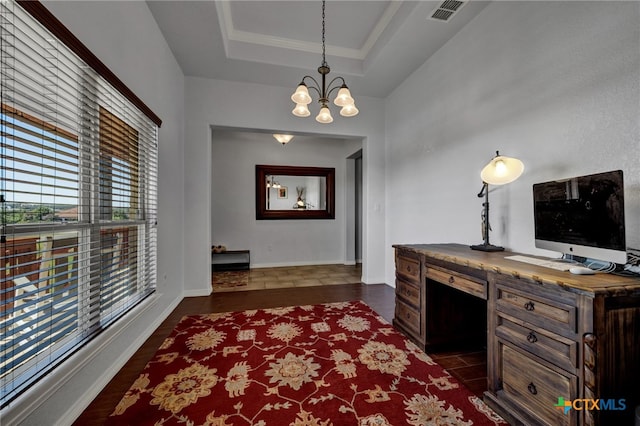 office space featuring a notable chandelier, crown molding, and a tray ceiling