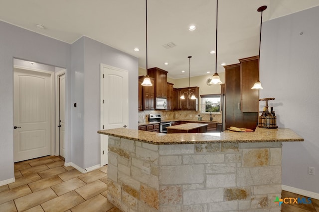 kitchen featuring backsplash, hanging light fixtures, appliances with stainless steel finishes, light stone counters, and kitchen peninsula