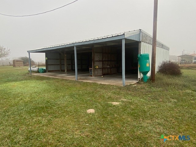 exterior space with a carport and a lawn