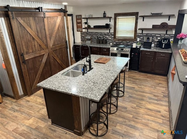 202 Clark St, Yoakum, TX 77995 - kitchen with open shelves, stainless steel gas range oven, and light wood-type flooring