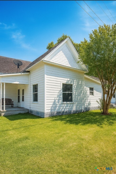 202 Clark St, Yoakum, TX 77995 - view of property exterior featuring a yard and a patio area