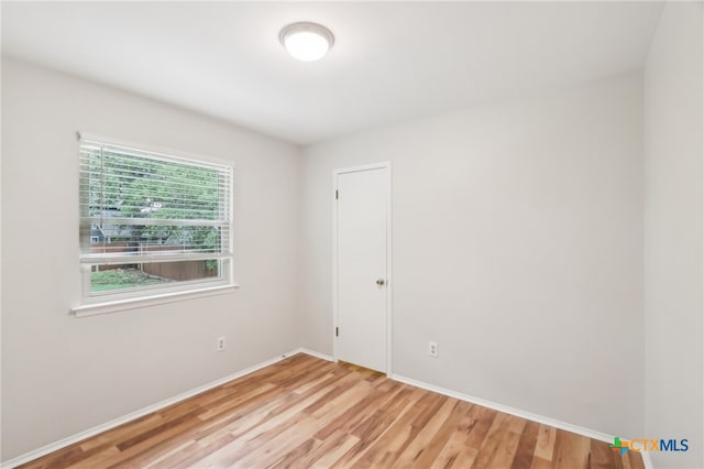unfurnished room with wood finished floors and baseboards
