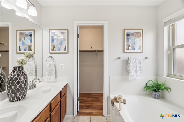full bathroom with healthy amount of natural light, a garden tub, tile patterned flooring, and a spacious closet