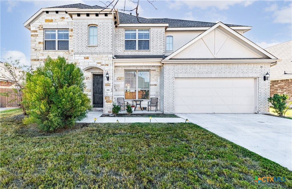 view of front of home featuring a garage and a front lawn