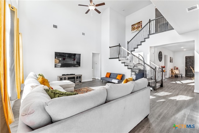 living room featuring a high ceiling, hardwood / wood-style floors, and ceiling fan