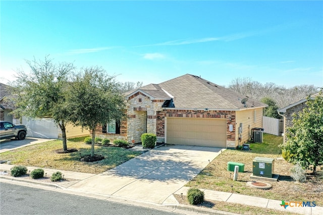 view of front of house featuring a garage, a front yard, and central air condition unit