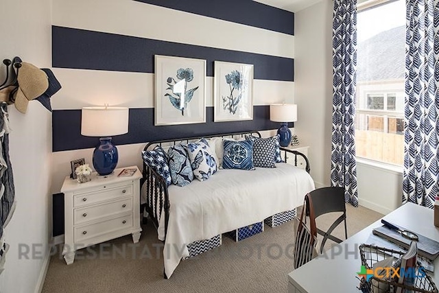 carpeted bedroom featuring baseboards and multiple windows