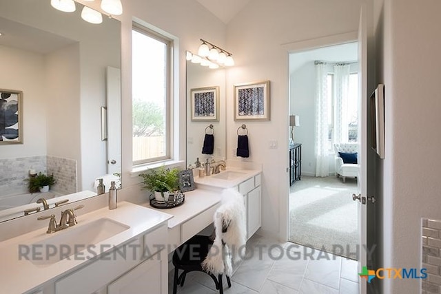 bathroom featuring double vanity, a sink, lofted ceiling, and ensuite bath