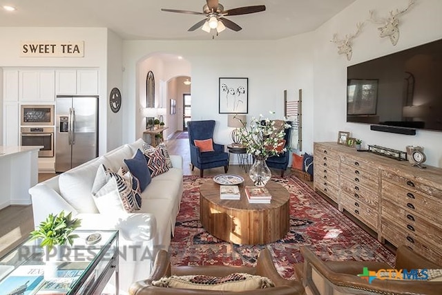 living room with arched walkways and ceiling fan