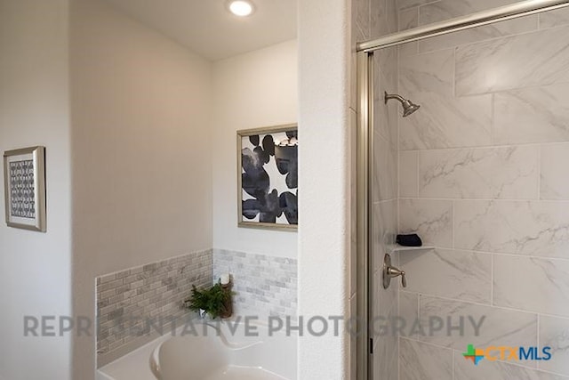 bathroom with a shower stall and a bath