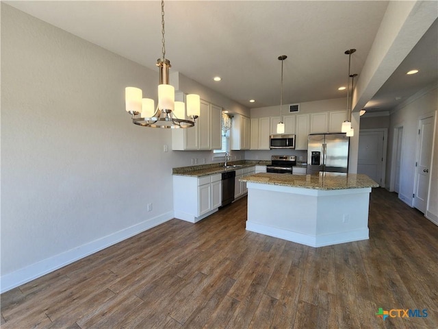 kitchen featuring baseboards, dark wood-style flooring, stainless steel appliances, white cabinetry, and a center island