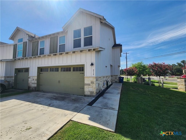 view of home's exterior with board and batten siding, fence, concrete driveway, a yard, and an attached garage