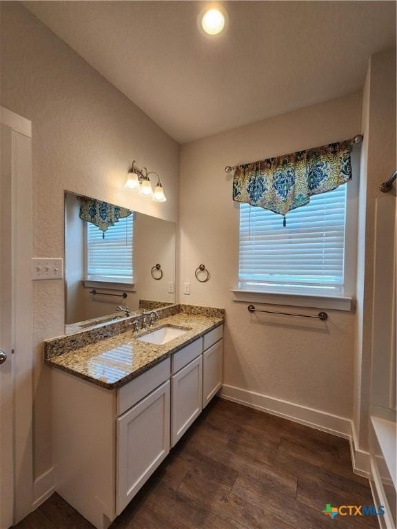 full bath with vanity, baseboards, and wood finished floors