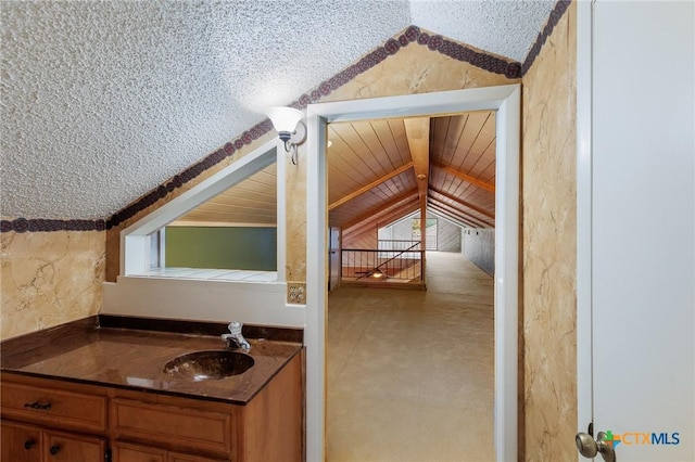 2820 Aurora, Horseshoe Bay, TX 78657 - bathroom with vaulted ceiling, vanity, and a textured ceiling