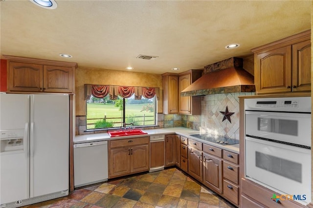 2820 Aurora, Horseshoe Bay, TX 78657 - kitchen with white appliances, custom exhaust hood, light countertops, dark stone finish flooring, and tasteful backsplash