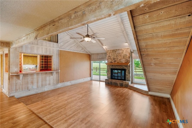 2820 Aurora, Horseshoe Bay, TX 78657 - unfurnished living room featuring wood finished floors, ceiling fan, a fireplace, wooden ceiling, and wood walls