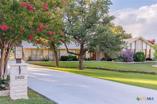 2820 Aurora, Horseshoe Bay, TX 78657 - view of front of property with stone siding, a front lawn, and a metal roof