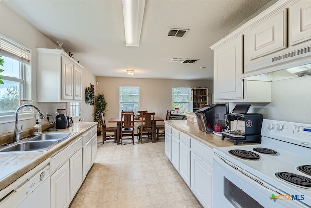 kitchen with premium range hood, sink, white cabinets, and white appliances